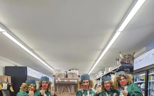 Gruppo di carnevale in costumi verdi tra gli scaffali del Gürkli